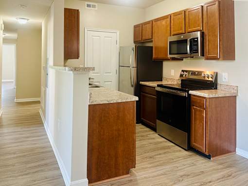 A kitchen with wooden cabinets and a black refrigerator  at The Greyson, OH