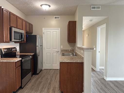 A kitchen with a black refrigerator and stove top oven  at The Greyson, Ohio