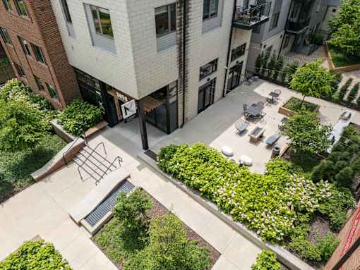A courtyard surrounded by buildings with a bench and a table. at The MK, Indiana