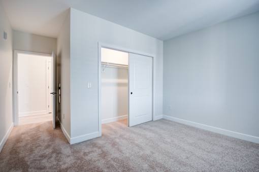 A room with a carpeted floor and two doors. at The MK, Indianapolis, IN