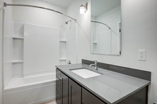 A modern bathroom with a white tub and sink. at The MK, Indiana