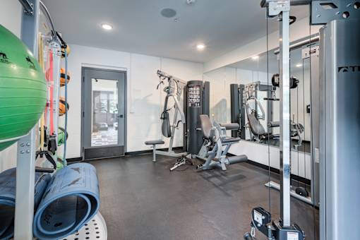 A gym with a variety of equipment including a green exercise ball. at The MK, Indianapolis, 46220