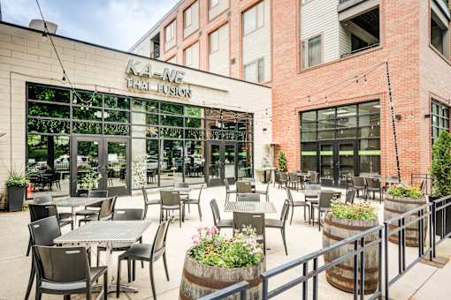 A restaurant named K1-NE Thai Fusion has tables and chairs set up on its patio.at The MK, 46220