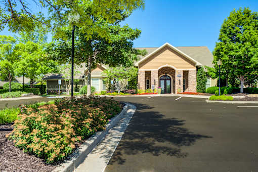 A building with a brown roof and a black door is surrounded by greenery at Sovereign at Overland Park Apartments, Kansas