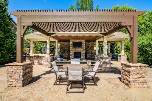A patio with a table and chairs under a pergola at Sovereign at Overland Park Apartments, Overland Park