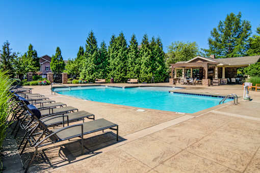 A large swimming pool surrounded by lounge chairs and trees at Sovereign at Overland Park Apartments, Overland Park, 66213
