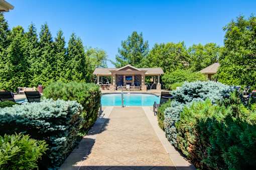 A backyard with a pool and a small house at Sovereign at Overland Park Apartments, Overland Park Kansas