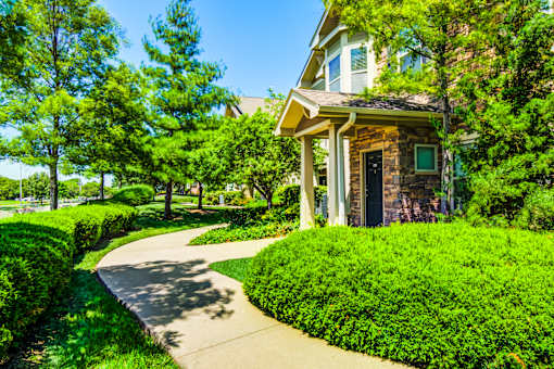 A house with a green lawn and a sidewalk in front at Sovereign at Overland Park Apartments, Kansas
