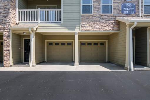 A building with a balcony and garage doors at Sovereign at Overland Park Apartments, Overland Park