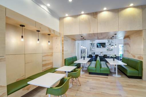 A modern dining area with green chairs and tables at Sovereign at Overland Park Apartments, Overland Park, 66213
