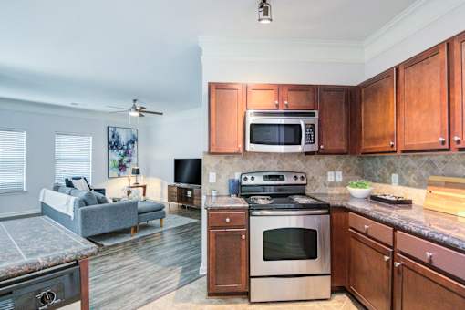 A kitchen with a stove top oven and microwave above it at Sovereign at Overland Park Apartments, Kansas