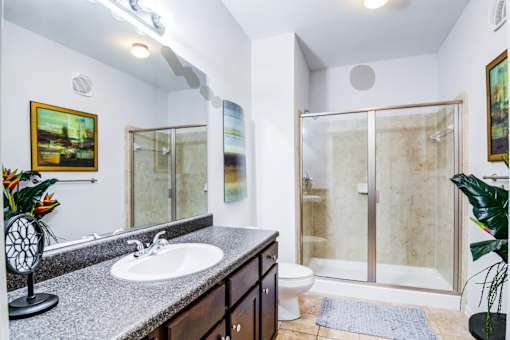A bathroom with a sink, mirror, and shower at Sovereign at Overland Park Apartments, Overland Park, KS 66213