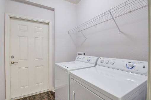 A white washer and dryer in a small laundry room at Sovereign at Overland Park Apartments, Kansas, 66213