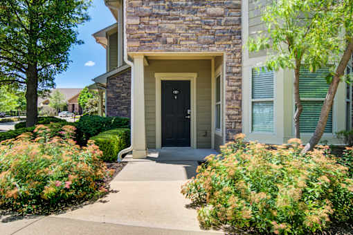 A house with a black door and a stone wall at Sovereign at Overland Park Apartments, Kansas, 66213
