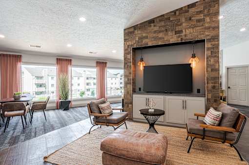 A living room with a flat screen TV mounted on a stone wall.