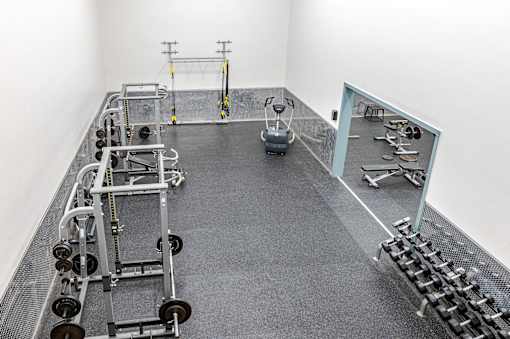 A gym with a variety of equipment including weights and a rowing machine.