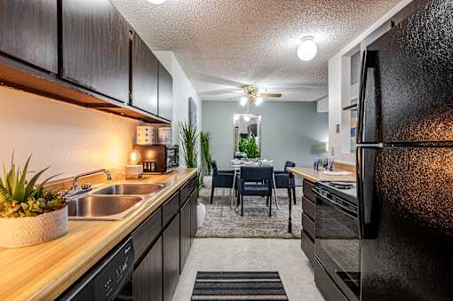 A kitchen with black cabinets and a wooden countertop.
