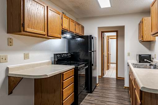 A kitchen with wooden cabinets and black appliances.