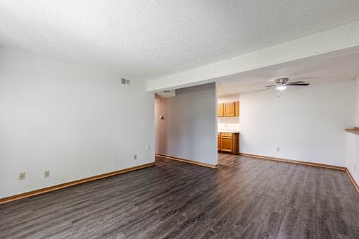 A room with a wooden floor and a ceiling fan.