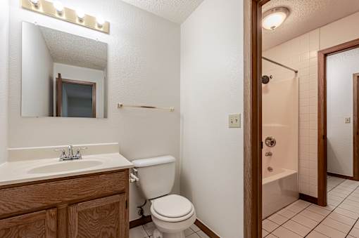 A bathroom with a toilet, sink, and shower.