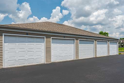A row of white garage doors in front of a building.