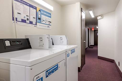 A laundry room with a washer and dryer and instructions on the wall.