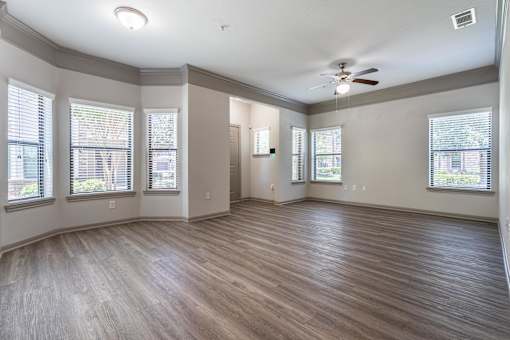 A room with wooden floors and a ceiling fan at Waterstone at Cinco Ranch Apartments, Katy, TX 77450