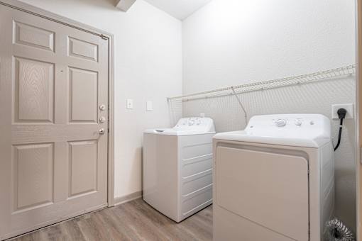 A laundry room with a washer and dryer at Waterstone at Cinco Ranch Apartments, Katy, TX