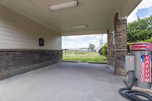 car wash bay featuring a high-powered vacuum unit and a covered washing area at Waterstone at Cinco Ranch Apartments, Katy, 77450