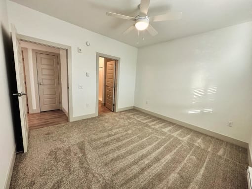 the living room of an empty house with a ceiling fan