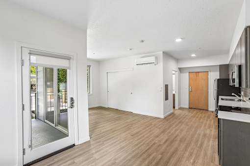 A modern kitchen with a wooden floor and white walls.
