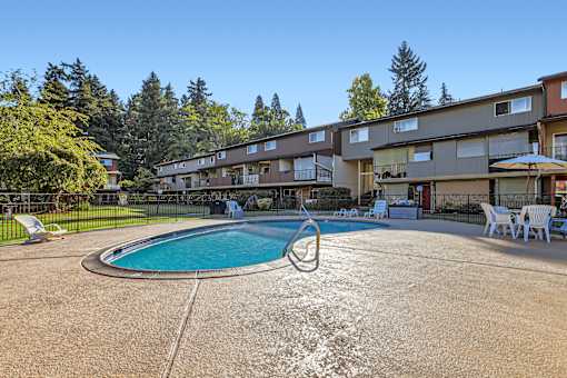 A swimming pool in front of apartment buildings.
