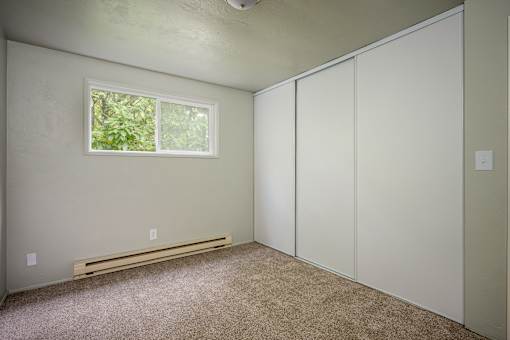 A room with a window, a bench, and a wall with a switch.