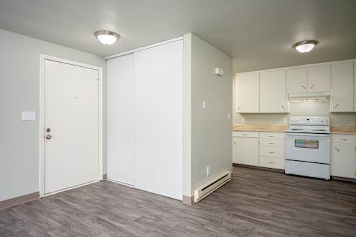 A kitchen with white cabinets and a white oven.