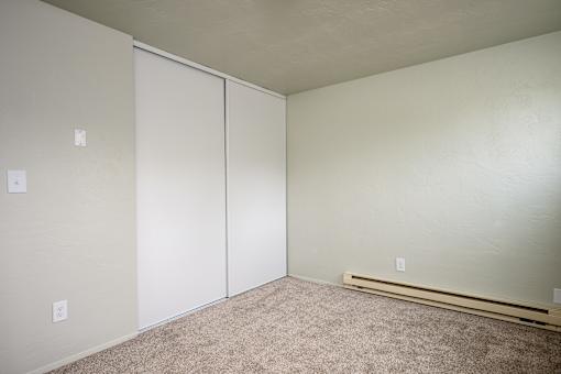 A room with a carpeted floor and a white door.