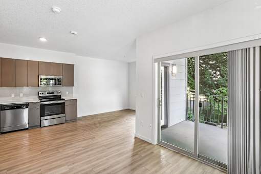 A modern kitchen with wooden floors and stainless steel appliances.