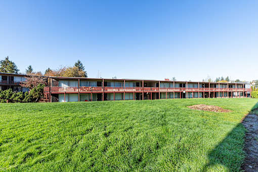 A long building with a lot of windows sits on a grassy field.