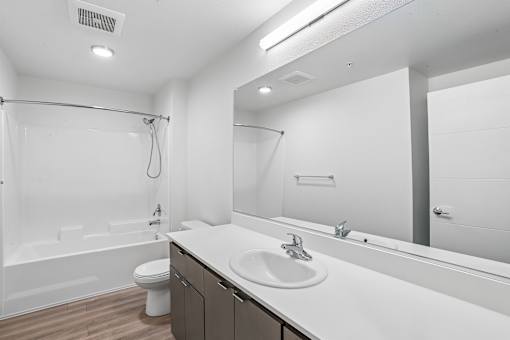 A white bathroom with a toilet, sink, and shower.