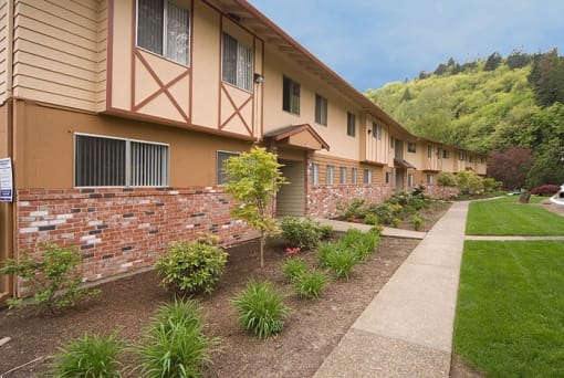 a row of apartments with a sidewalk and landscaping