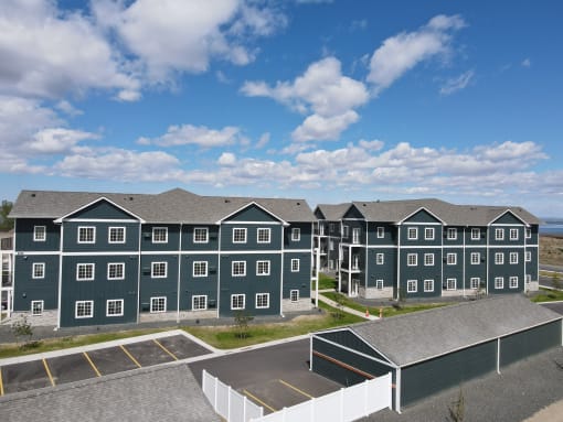 a row of green houses in front of a blue sky