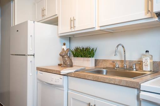 A kitchen with a white fridge and a white washing machine.