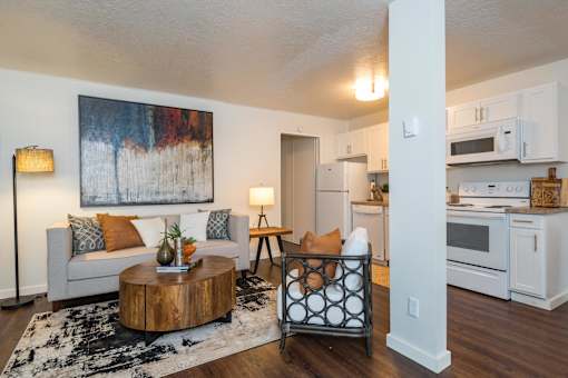 A living room with a white couch and a painting on the wall.