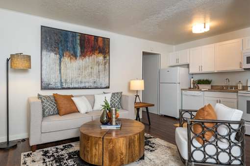 A living room with a couch, a coffee table, and a painting on the wall.