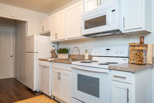 A kitchen with white appliances and cabinets.