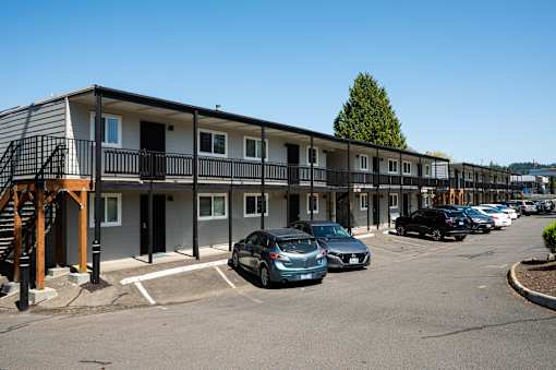 A parking lot with cars and apartment building