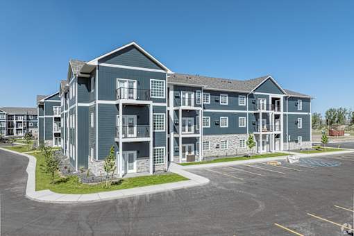 an apartment building with a parking lot and a street