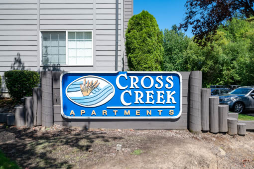 a sign in front of a building that says cross creek apartments