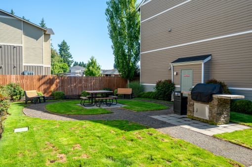 a backyard with a grill and picnic table