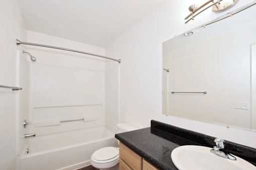 A white bathroom with a toilet, sink, and bathtub.