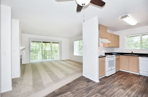 A kitchen with white cabinets and a striped rug on the floor.